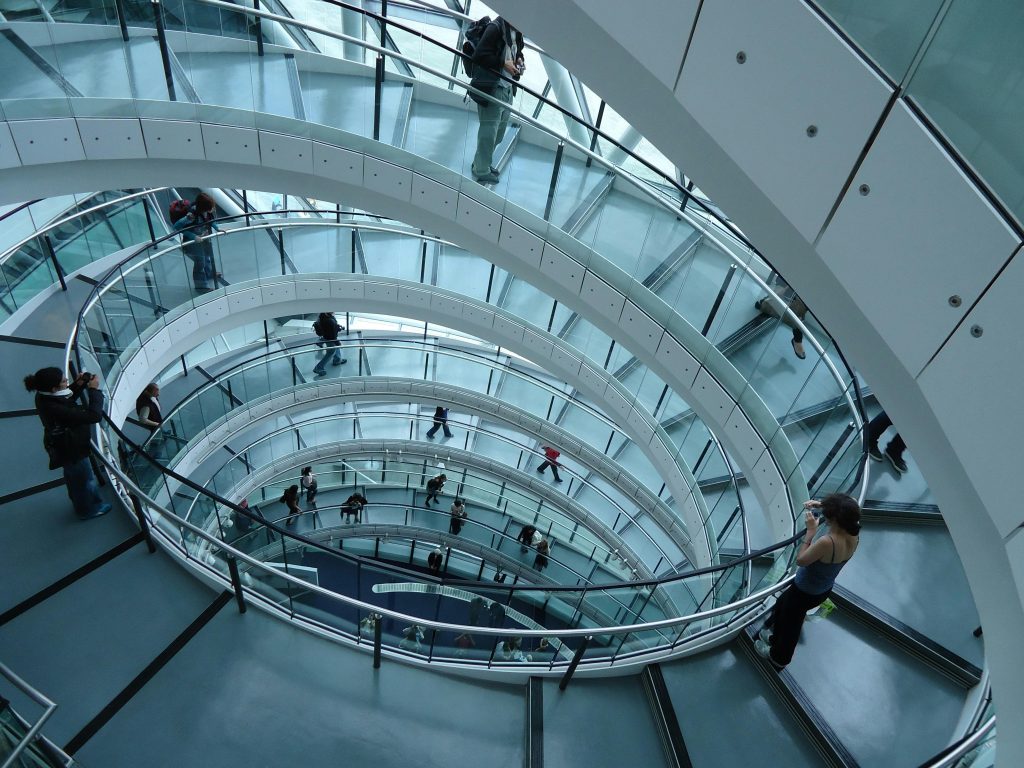 pexels-photo-417348-417348 Aerial view of people on a contemporary spiral staircase with glass railings.